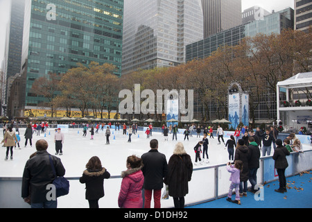 La pista di pattinaggio su ghiaccio è sempre occupato a Bryant Park durante la stagione di festa dietro la NY Public Library in NYC. Foto Stock