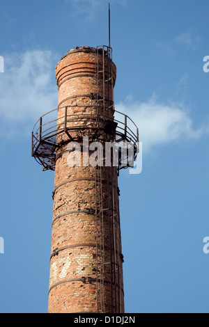 Vecchia ciminiera in mattoni con parafulmine contro un cielo blu Foto Stock