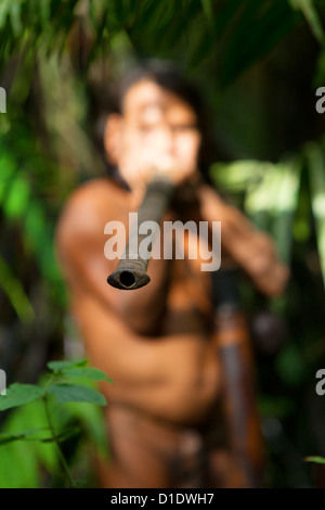 Tipico Huaorani Hunter ritratto Waorani riserva Yasuni National Park Ecuador sparare nella giungla di luci ambiente Focus sulla pistola ad aria compressa Foto Stock