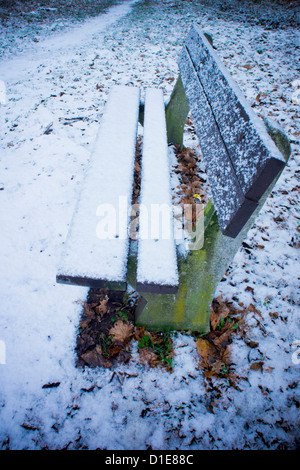 Vecchia panca di legno in un parco, coperte di neve Foto Stock