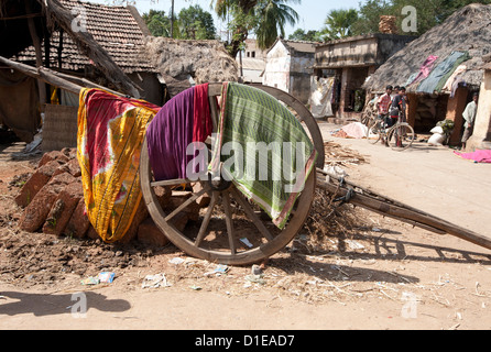 Lavaggio e asciugatura su carrello di legno ruota del camion di legno in strada, tessitura Naupatana villaggio rurale, Orissa, India, Asia Foto Stock