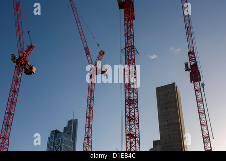 Gru e cielo blu su un grande sito di costruzione a Broadgate sviluppo nella City di Londra. Guardando verso l'alto da un angolo basso, vediamo solo due nuvole in una altrimenti cielo blu, con quattro del progetto raggiungendo gru verso l'alto, il cemento armato albero di sollevamento di un nuovo edificio in rapida crescita e il completamento di un blocco sulla sinistra. Broadgate è un grande, 32 acri (13 ha) office e retail station wagon nella City di Londra, di proprietà di terra britannica e il Gruppo Blackstone e gestito da Broadgate Estates. Lo sviluppatore originale era Rosehaugh: è stato costruito da un Bovis / Tarmac Construction joint venture Foto Stock
