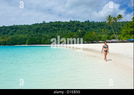 Tourist vagare lungo le acque turchesi e la sabbia bianca di La spiaggia Champagne, Isola di Espiritu Santo, Vanuatu, Sud Pacifico Foto Stock