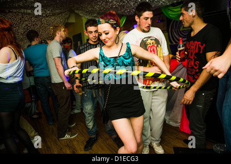 Una ragazza di ballare con un hula hoop - Aberystwyth studente universitario partying a dance notte nell'unione degli allievi, Wales UK Foto Stock