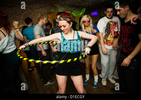 Una ragazza di ballare con un hula hoop - Aberystwyth studente universitario partying a dance notte nell'unione degli allievi, Wales UK Foto Stock