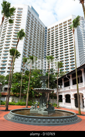 Fontana in classico stile coloniale con alto edificio moderno su sfondo, Singapore Foto Stock