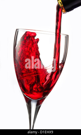 Ferma l'azione foto di natura morta del vino rosso versato in un bicchiere su sfondo bianco Foto Stock