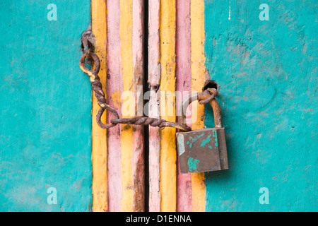 Serratura vintage e la catena su un vecchio colorato porta in legno Foto Stock