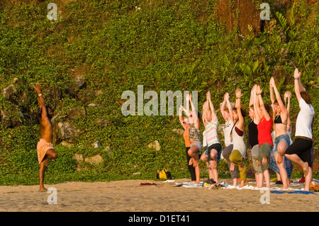 Vista orizzontale di un turista in una classe di yoga tenuto sulla spiaggia di Varkala, Kerala. Foto Stock