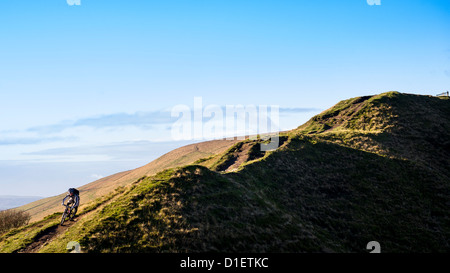 Mountain Biker scorre giù per un sentiero collinare nel Peak District, England, Regno Unito Foto Stock