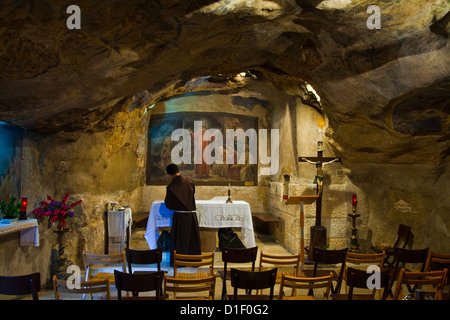 Monaco preparando l'altare nella Grotta del Giardino del Getsemani, Gerusalemme Foto Stock