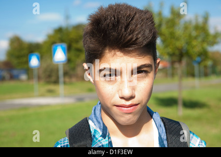 Ragazzo di fronte a segnali stradali, ritratto Foto Stock