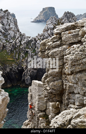 Rocciatore al di sopra di La Salle Verte con vista verso Les Tas de Pois, Pointe de Penhir, Finistère Bretagna, Francia Foto Stock