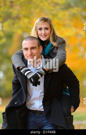 Uomo Donna portante piggyback nel paesaggio autunnale Foto Stock