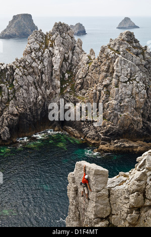 Rocciatore al di sopra di La Salle Verte con vista verso Les Tas de Pois, Pointe de Penhir, Finistère Bretagna, Francia Foto Stock