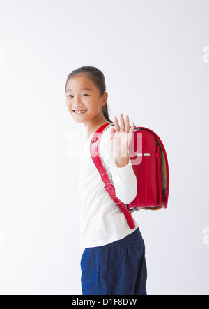 La ragazza che porta un sacco di scuola sulle spalle Foto Stock