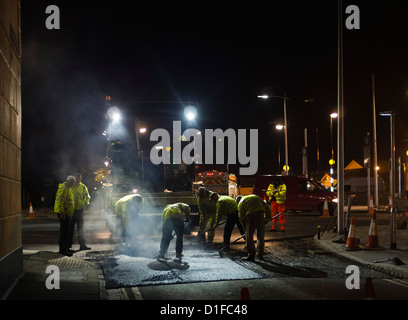 Una pista di operai posa di asfalto su una strada di notte, REGNO UNITO Foto Stock