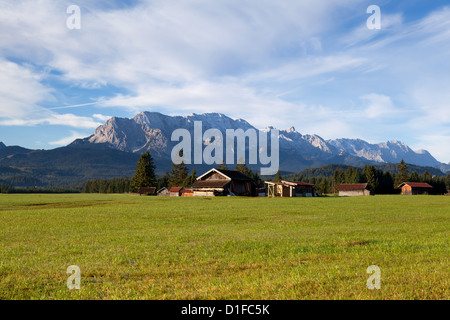 Capanne in legno su prati alpini in luce del sole di mattina Foto Stock