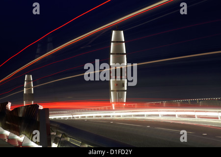 Traffico sentieri di luce su letti di vele il sollevamento ponte che attraversa il porto di Poole a Poole, Dorset Regno Unito nel mese di dicembre Foto Stock