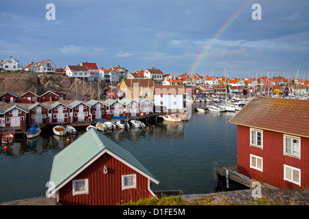 Colorate di pesca tradizionali capanne e boathouses con barche lungo il molo in legno a Smögen, Bohuslän, Svezia e Scandinavia Foto Stock