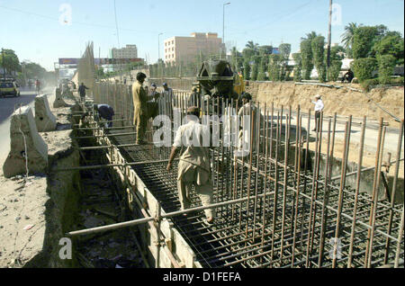 Operai impegnati nel loro lavoro come la costruzione del cavalcavia è nel suo progresso sotto la supervisione di Karachi Metropolitan Corporation (KMC) a Shahrah-e- Pakistan vicino Aisha Manzil a Karachi il Mercoledì, 19 dicembre 2012. Foto Stock