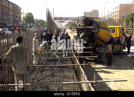 Operai impegnati nel loro lavoro come la costruzione del cavalcavia è nel suo progresso sotto la supervisione di Karachi Metropolitan Corporation (KMC) a Shahrah-e- Pakistan vicino Aisha Manzil a Karachi il Mercoledì, 19 dicembre 2012. Foto Stock