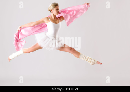 Graziosa ballerina jumping esercitando in studio donna ballerina prova Foto Stock