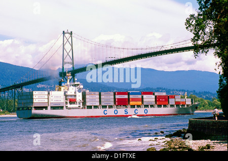 Caricato contenitore di carico della nave mercantile / entrando in porto di Vancouver Harbor sotto il Ponte Lions Gate, BC, British Columbia, Canada Foto Stock