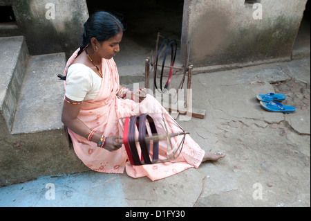 La donna la filatura filo di seta a mano al di fuori della propria casa, Vaidyanathpur, Orissa, India, Asia Foto Stock
