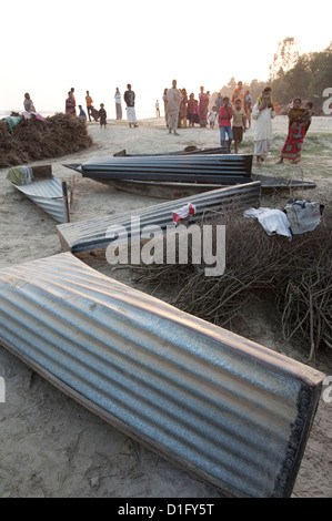 Piccole imbarcazioni realizzate a partire da fogli di lamiera ondulata, adagiata sulle rive del fiume Hugli (Fiume Hooghly), West Bengal, India Foto Stock