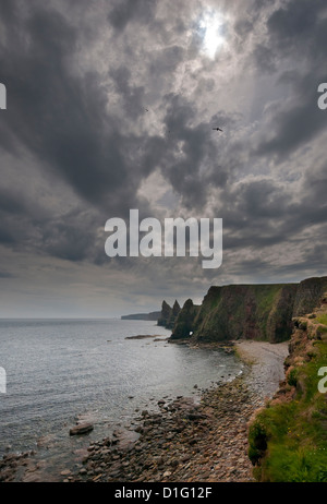 Scogliere e pile a testa di Dunnett, Caithness, Highland, Scozia; con nuvoloso cielo nuvoloso. Foto Stock