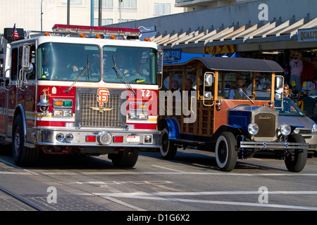 San Francisco Fire Department scala a carrello e un vintage tour Packard a veicolo in marcia a San Francisco, California, Stati Uniti d'America. Foto Stock