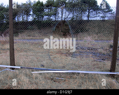 Foro ricavato in un filo danneggiato recinto di sicurezza intorno a un vuoto di un appezzamento di terreno, vicino a Swansea, South Wales, Dicembre 2012 Foto Stock