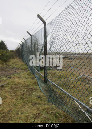 Filo danneggiato recinto di sicurezza intorno a un vuoto di un appezzamento di terreno, vicino a Swansea, South Wales, Dicembre 2012 Foto Stock