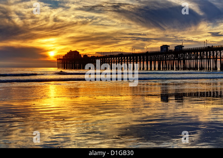 Oceanside pier e riflessioni, catturata su un estremamente bassa marea di sera. Foto Stock