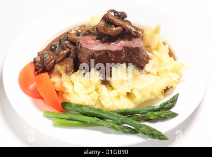 Chateaubriand filetto di manzo condito con una salsa di funghi servito su un letto di patate con asparagi e fette di pomodoro. Foto Stock