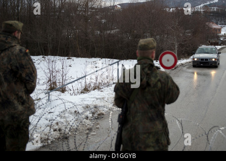 Deutsche Soldaten der Kosovo-Schutztruppe KFOR bewachen am 20.12.2012 in Zupce im Kosovo eine Straßensperre. Verteidigungsminister Thomas de Maiziere besucht für einen Tag die deutschen KFOR-Soldaten im Kosovo. Foto: Axel Schmidt/dpa (zu dpa 0488 vom 20.12.2012) Foto Stock