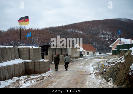 Deutsche Soldaten der Kosovo-Schutztruppe KFOR gehen am 20.12.2012 in Zupce im Kosovo eine Straße entlang. Verteidigungsminister Thomas de Maiziere besucht für einen Tag die deutschen KFOR-Soldaten im Kosovo. Foto: Axel Schmidt/dpa (zu dpa 0488 vom 20.12.2012) Foto Stock