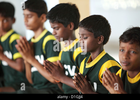 Vijayawada, India, ragazzo meditando nella parte anteriore dei pasti scolastici in SKCV villaggio per bambini, una risorsa per i bambini di strada Foto Stock