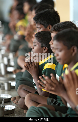 Vijayawada, India, ragazzo meditando nella parte anteriore dei pasti scolastici in SKCV villaggio per bambini, una risorsa per i bambini di strada Foto Stock