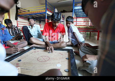 Chennai, India, ragazzi all'orfanotrofio a giocare il gioco del bordo del carrom Foto Stock