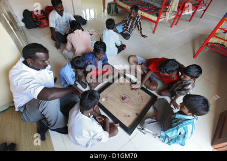 Chennai, India, ragazzi all'orfanotrofio a giocare il gioco del bordo del carrom Foto Stock