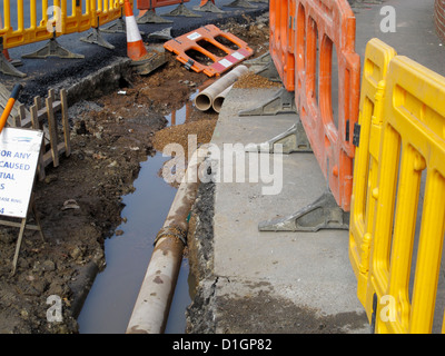 La riparazione dei danni della superficie urbana di acqua della tubazione di drenaggio infrastrutture fatiscenti Exeter Regno Unito Foto Stock