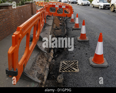 La riparazione dei danni della superficie urbana di acqua della tubazione di drenaggio infrastrutture fatiscenti Exeter Regno Unito Foto Stock