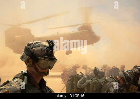 Noi soldati dell esercito prendere la copertura mentre un CH-47D elicottero Chinook terre in un deserto ubicazione vicino a Samarra in Iraq 11 maggio 2006. Foto Stock