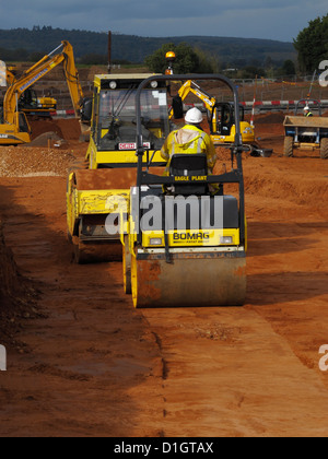 Bomag strada compattazione a rullo di compattazione del terreno di riempimento durante la fase di lavori di sterro di strada la costruzione dell'edificio sito nel Regno Unito Foto Stock