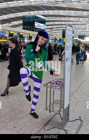 21 dicembre 2012. T5 L'aeroporto di Heathrow di Londra. Un attore vestito in un costume di elf per intrattenere i viaggiatori, su ciò che è stato previsto per essere il giorno di punta per il Natale Viaggio. © Danny Callcut Foto Stock