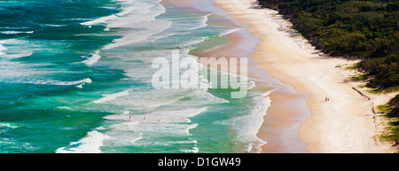 Foto panoramica di surfers di uscire a navigare sul sego spiaggia di Cape Byron Bay, Nuovo Galles del Sud, Australia Pacific Foto Stock