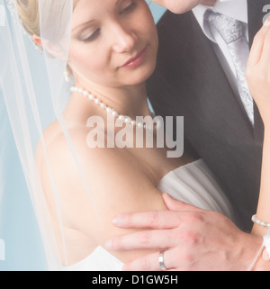 Momento romantico tra la sposa e lo sposo sotto un velo Foto Stock