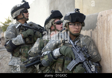 Noi soldati dell esercito attendere il segnale per entrare in una casa mentre si conduce un piede in pattuglia Bayji, Iraq 10 Dicembre 2005. Foto Stock